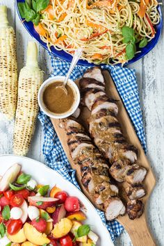 grilled chicken, pasta and vegetables on a table