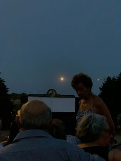 a woman standing on top of a stage in front of an audience at a film festival