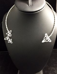 a necklace with two hearts on it sitting on a mannequin