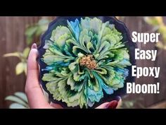 a person holding up a flower with the words super easy epoxy bloom on it