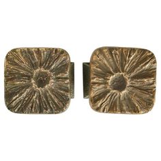 two square brass knobs with an intricate design