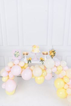 a table topped with lots of balloons and cake