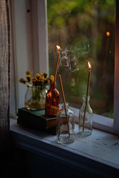 a window sill with two bottles and candles on it next to a window sill