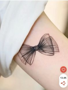 a small bow tattoo on the left side of the right arm is shown in black ink