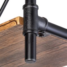 a black pipe is attached to the side of a wooden structure with metal fittings