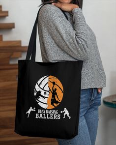 a woman holding a purple tote bag with an image of a basketball player