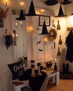 a room decorated for halloween with candles and witches hats hanging from the ceiling, while other decorations are on the wall