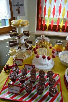 an assortment of desserts on a table with candy bars and cupcakes in the background