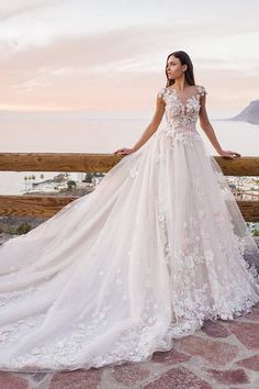 a woman in a wedding dress standing on a balcony