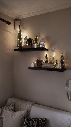 two shelves that have lights on them above a couch in a room with white walls