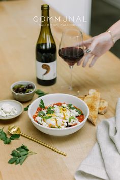 a bowl of food and some wine on a table