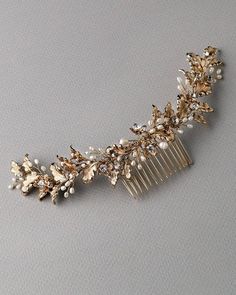 a gold comb with pearls and leaves on it