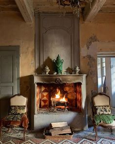 an old fireplace in the middle of a living room with chairs and a painting on the wall