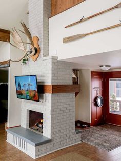 a living room with a fireplace, television and deer antlers on the wall above it