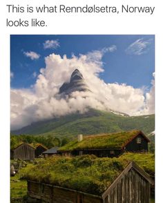 a green roof on top of a building with clouds in the sky above it and an image of a mountain behind it