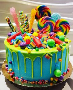 a colorful cake with candy and lollipops on top