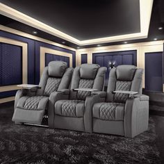 an empty theater with two recliners in front of the seats and a table on the other side