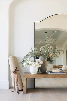 there is a mirror and vases on the table in front of the couches