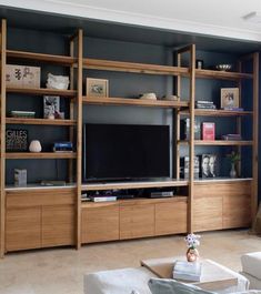 a living room with shelves and a tv on top of it's entertainment center