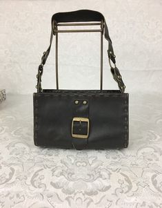 "Here we have a vintage brown leather footed Purse with a wide strap, metal studs and large buckle. This has a great retro look. This is in very nice condition considering its age. I noticed some light scratches but no ther problems. It measures: Height - 6\" Width - 9 3/4\" Depth - 4 1/4\" Strap Drop - 11 1/4\" I try my best to give accurate descriptions, although I am no expert, plus I'm human and sometimes I might miss a flaw. I always provide high resolution photos and consider them to be pa Brown Leather Purse, Boho Bag, Studded Leather, High Resolution Photos, Retro Look, Wide Straps, Leather Purse, Vintage Brown, Leather Satchel