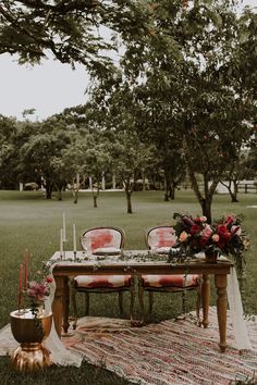 an outdoor table set up with red chairs