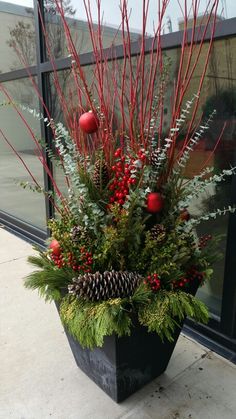 a planter filled with red berries and greenery