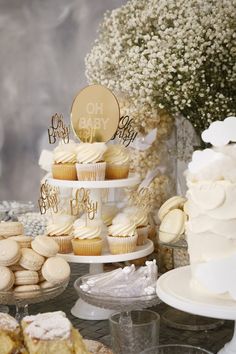 a table topped with lots of cupcakes and cakes