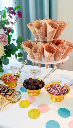 an assortment of desserts on a table with flowers in the backgroung