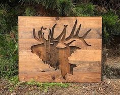 a wooden sign with an image of a moose's head and antlers on it