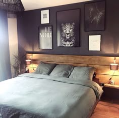 a bed with two pictures on the wall above it