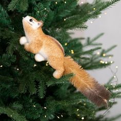 a stuffed squirrel hanging from the top of a christmas tree