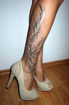 a woman's legs with tattoos and high heels