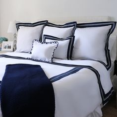 a bed with white and blue comforters in a bedroom