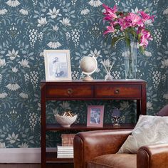 a brown chair sitting next to a wooden table with flowers on it's side