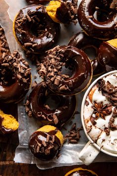 chocolate donuts with white frosting and sprinkles are on the table