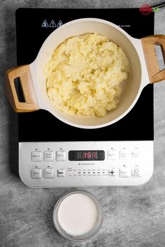 a bowl of mashed potatoes sitting on top of a scale next to a glass of milk