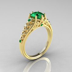 a gold ring with green stones on the side and an oval shaped diamond in the center