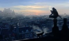 a man sitting on top of a roof next to a bird in the city at sunset