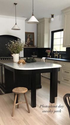 a kitchen with an island in the middle of it and two stools next to it