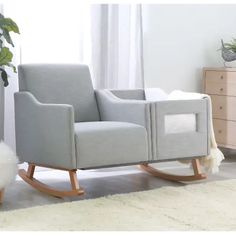 a gray rocking chair sitting on top of a white rug