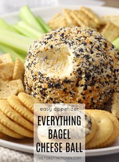 everything bagel cheese ball on a plate with crackers and celery