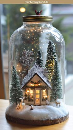 a glass jar filled with snow covered houses and trees