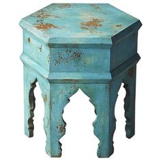 an old blue wooden stool sitting on top of a table