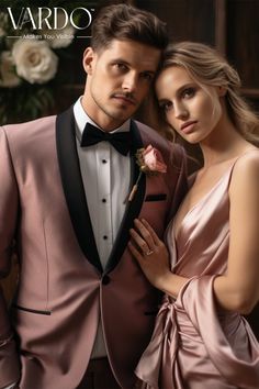 a man in a tuxedo standing next to a woman wearing a pink dress