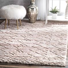 a white rug in a living room next to a chair and vase on the floor