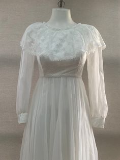 a white dress with sheer sleeves on a mannequin