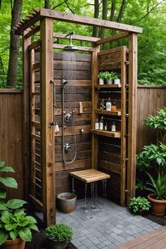 an outdoor shower in the middle of a garden with potted plants and trees around it