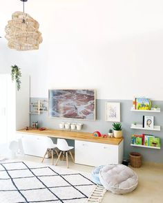 a living room filled with furniture next to a wall mounted art work on the wall