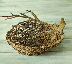 a bowl made out of branches on a wooden table