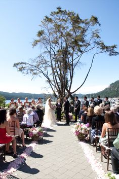 a bride and groom are walking down the aisle at their wedding ceremony by the water